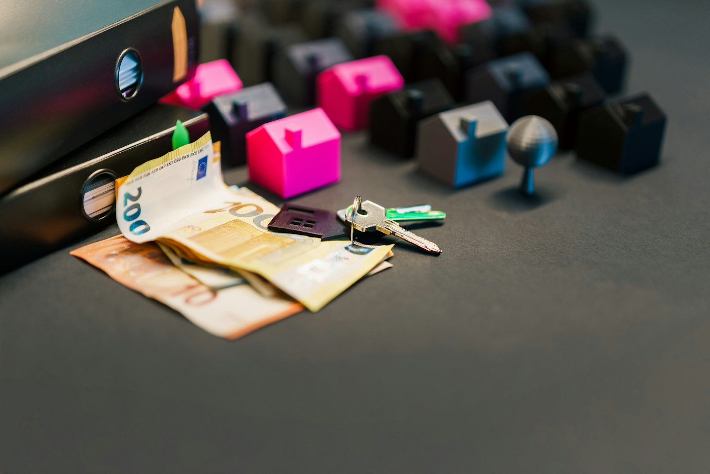 Billets en euros, clés et maquettes de maisons sur une table