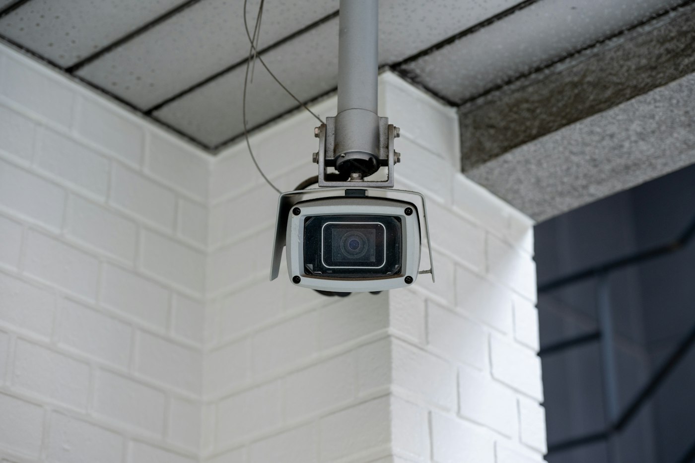 Caméra de vidéosurveillance fixée sur un mur en briques